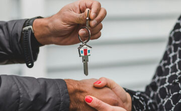 Real estate agent passing a house key to a client.