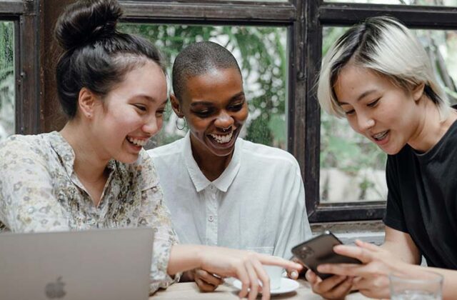 Group of people sitting and taking online surveys on a phone.