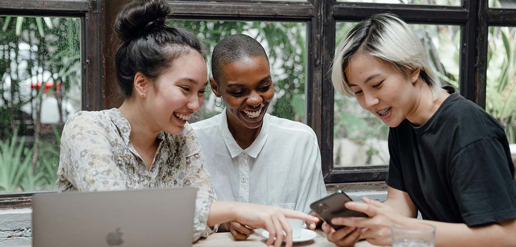 Group of people sitting and taking online surveys on a phone.