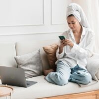 Woman relaxing on her couch playing Freecash for money.