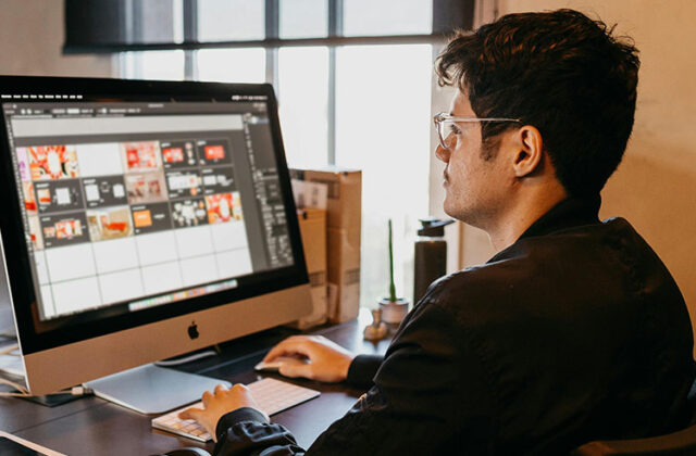 Professional graphic designer sitting at a computer and browsing graphics