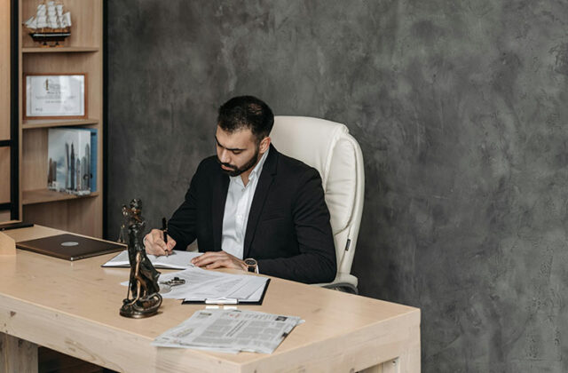 Consultant sitting at a desk and writing down notes from a consulting job