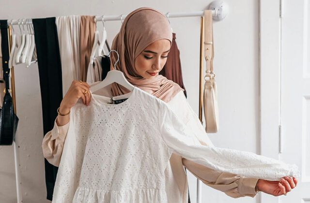 SHEIN product tester holding up a shirt before trying it on for the first time.