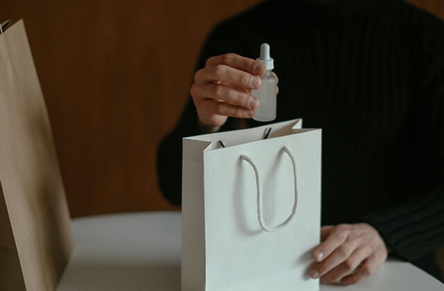 Close view of an Amazon product tester holding a bag with free products in it.