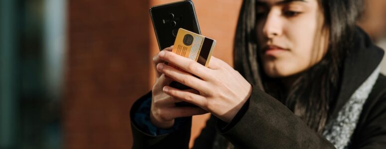 Ibotta user holding a phone and a credit card just after making a purchase.