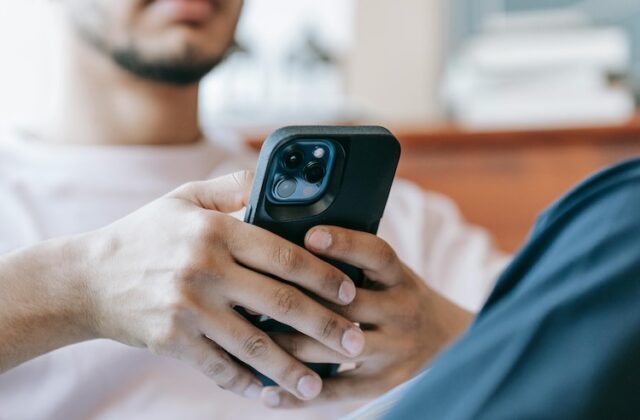 Man playing games for money for Scrambly on his phone.