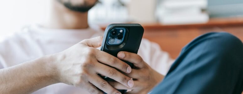 Man playing games for money for Scrambly on his phone.