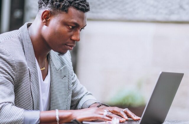 Man sitting at his laptop hunting for a job using automated AI tools.