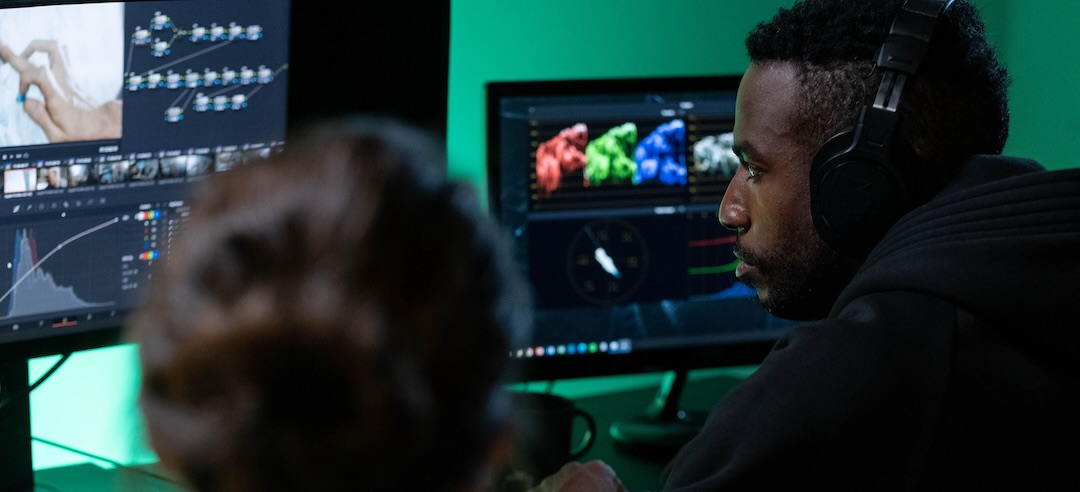 Two animators on a computer performing post-production to a video.