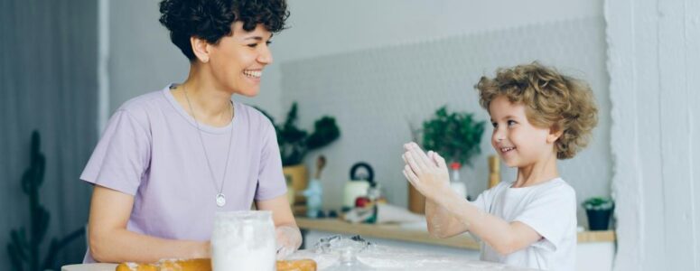 Professional nanny or babysitter doing a home baking activity with a young child