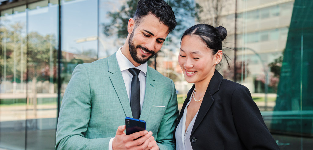 Man and woman looking at their investments on a smartphone together