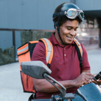 DoorDash worker looking at his phone in between orders.