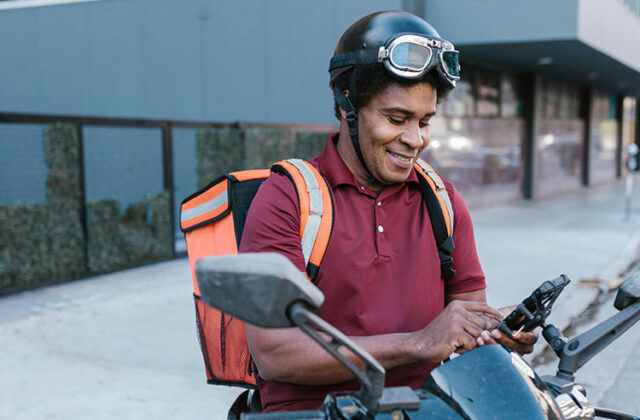 DoorDash worker looking at his phone in between orders.