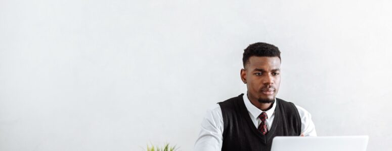 Black freelancer reading a negative review from a biased client.