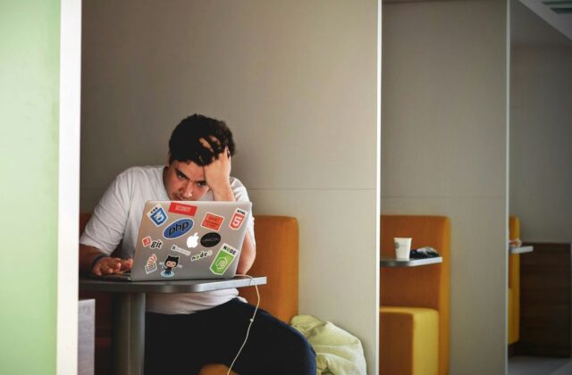 Burned out worker sitting at his laptop working on his side hustle.