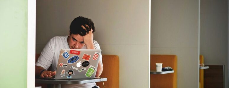 Burned out worker sitting at his laptop working on his side hustle.