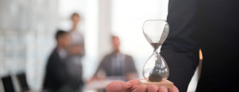 Close view of a businessman holding an hourglass.