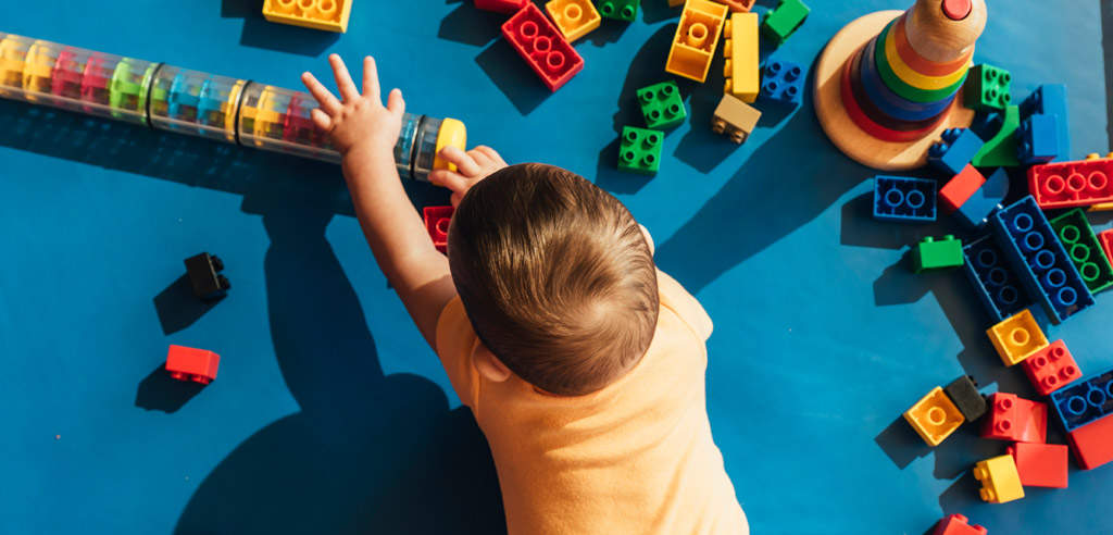 Child playing with brightly colored toys and blocks