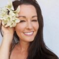 Professional craft seller Jessica Kennedy smiling with a large, white flower in her hair