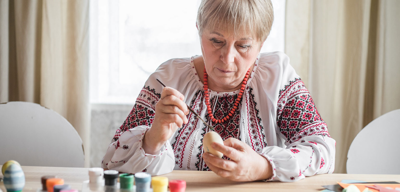Older woman painting a small object to sell online