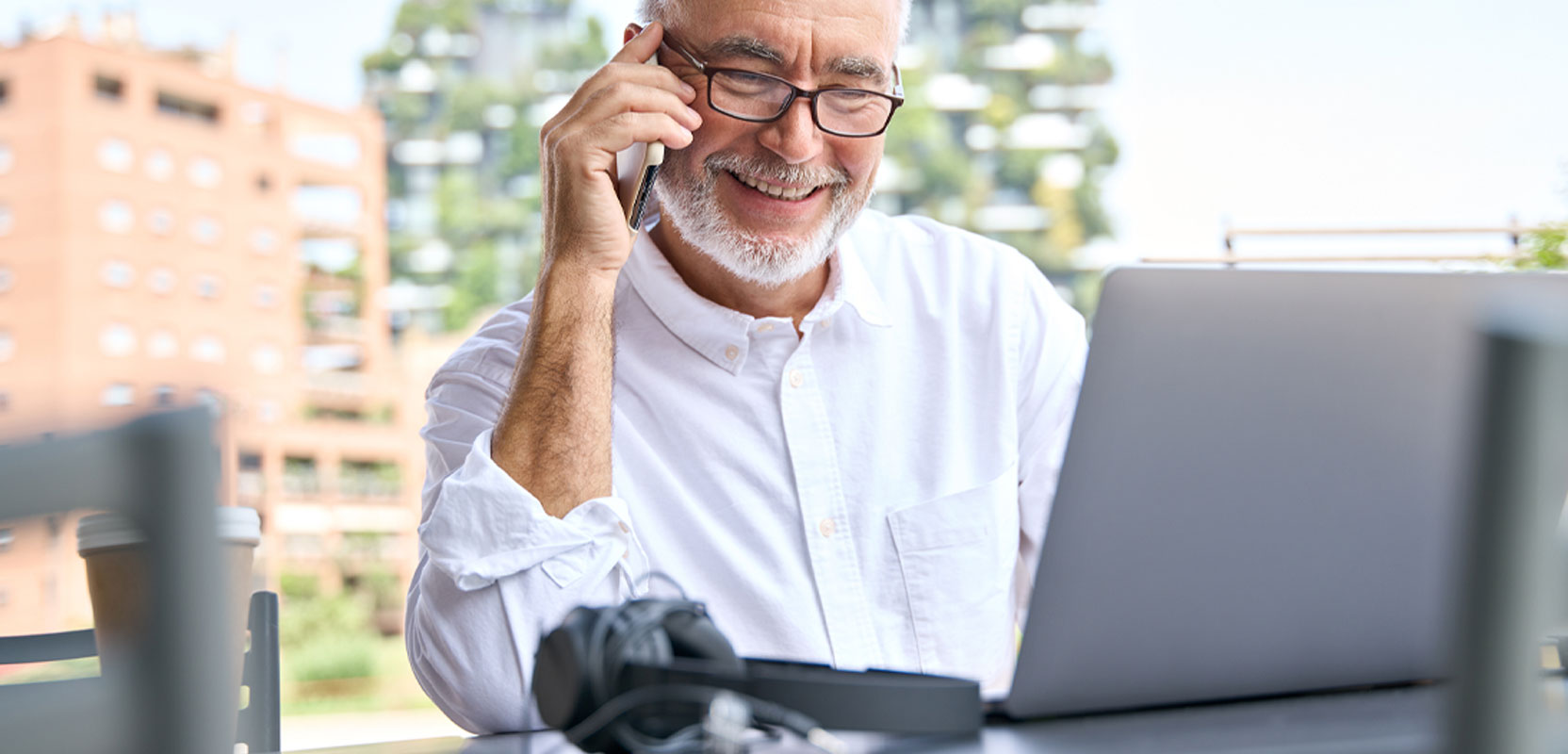 Bearded older man on the phone working as a part-time customer service representative