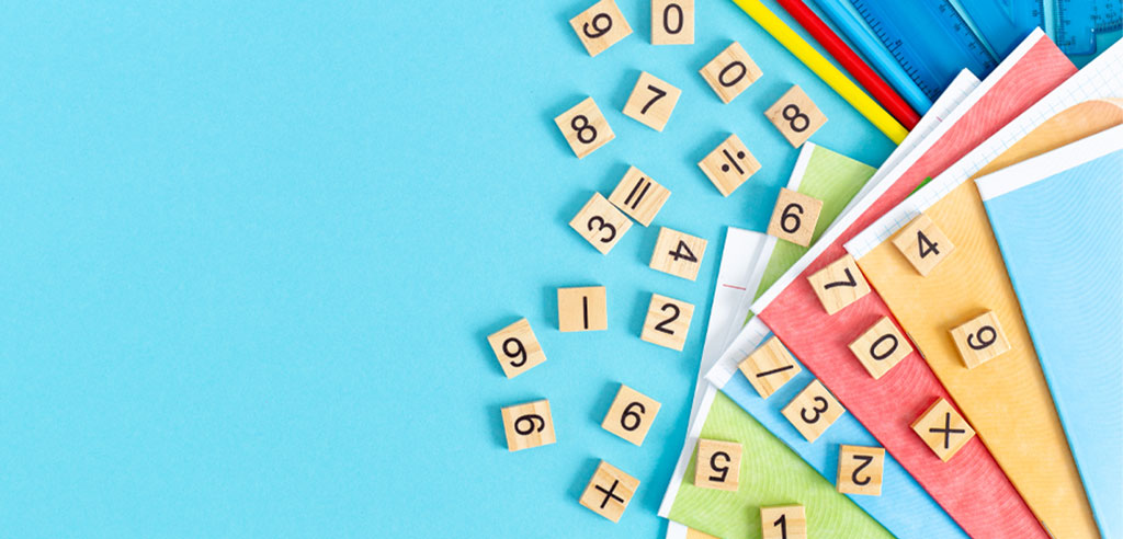 Wooden blocks with numbers and mathematical symbols on them representing being a math tutor
