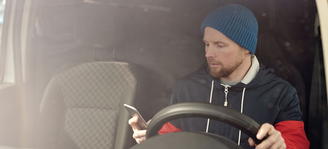 Delivery driver looking at his phone.
