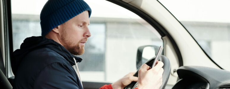 Delivery driver on his phone in his car.