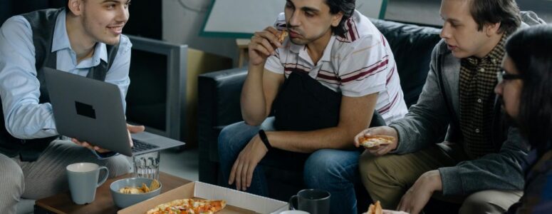 Employees sitting and eating pizza in their break room.