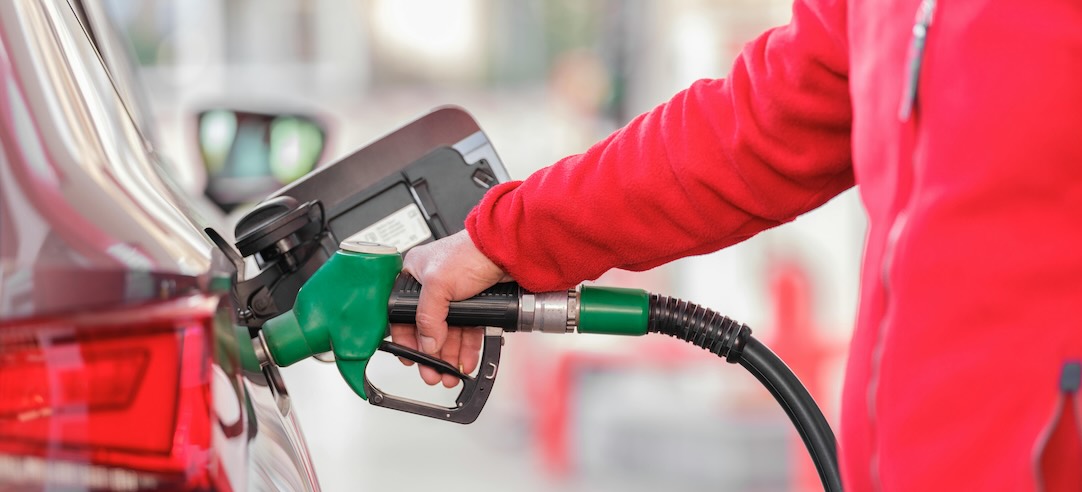 A person refilling the fuel tank on a car.