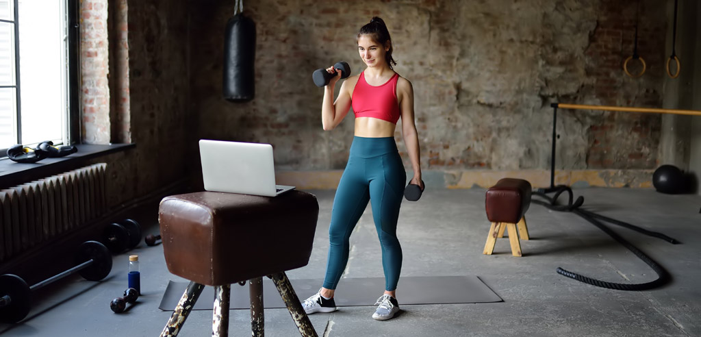Personal trainer conducting a session over video call in her home gym