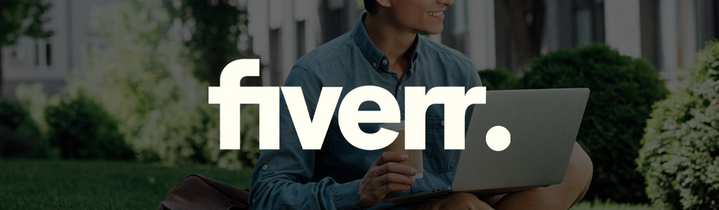 Fiverr logo against a darkened background showing a male freelancer typing on a laptop