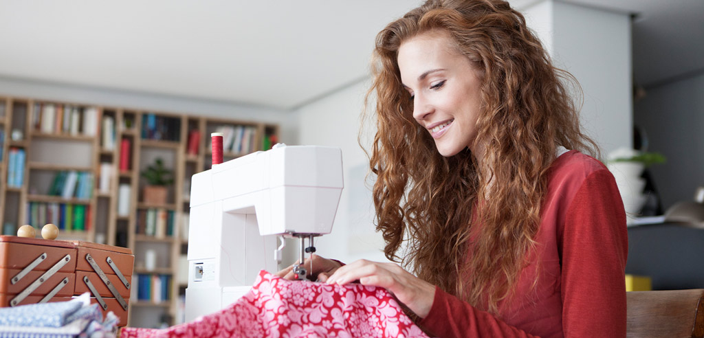 Woman using her sewing machine at home to repair clothing to flip online