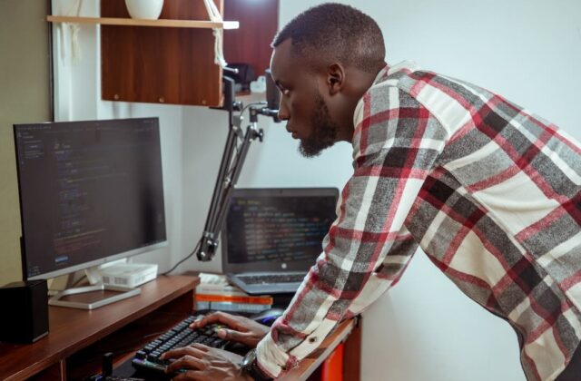 Freelance software developer writing code on a computer.