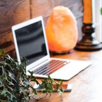 Freelance writer's laptop sitting on a desk next to a salt lamp.