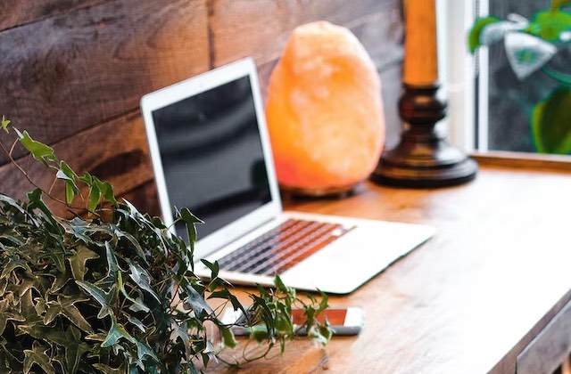 Freelance writer's laptop sitting on a desk next to a salt lamp.