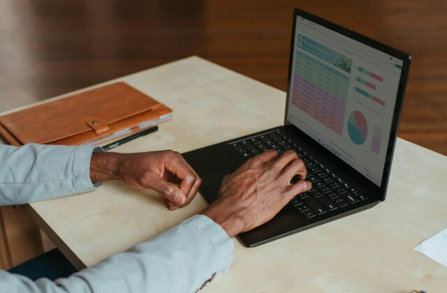 Close view of a freelancer's hands as they sit at their laptop working on a project.