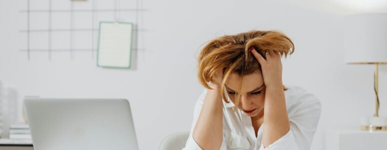 Job seeker pulling her hair in frustration after being rejected due to her employment status.