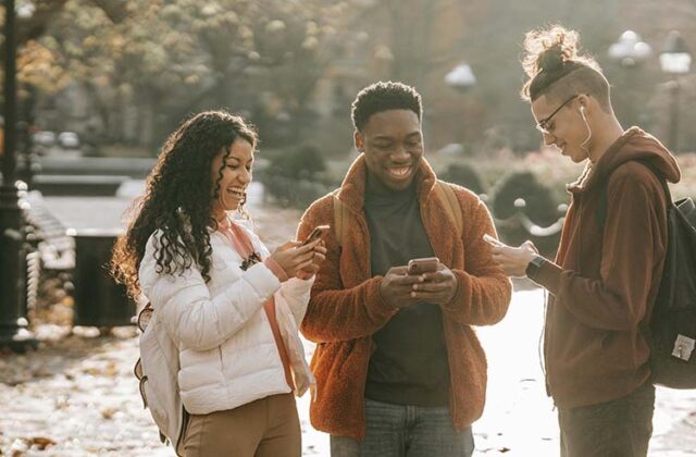 Couple walking and playing games that pay money on their phones.