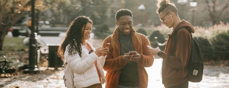 Couple walking and playing games that pay money on their phones.