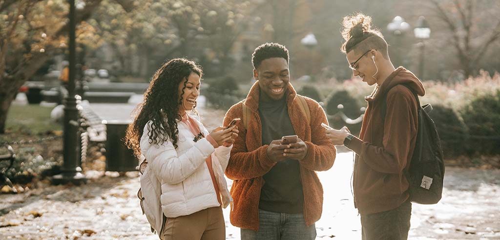 Couple walking and playing games that pay money on their phones.