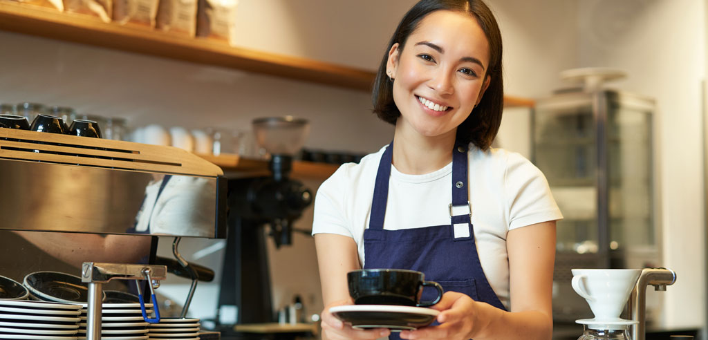 Female barista serving coffee as part of her side job