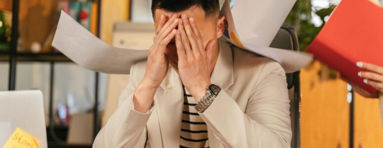A stressed worker overwhelmed with paperwork after a ghost promotion.