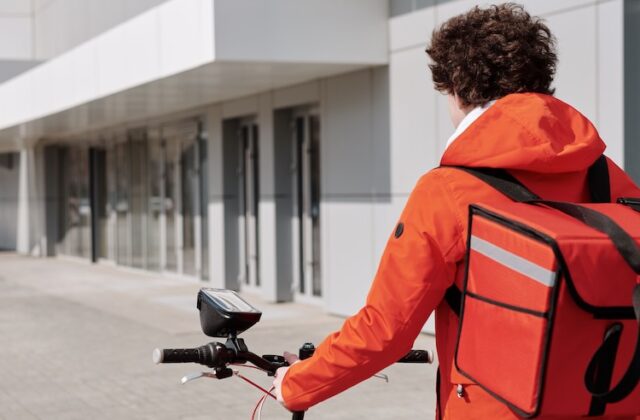 Bike courier walking with a bicycle.
