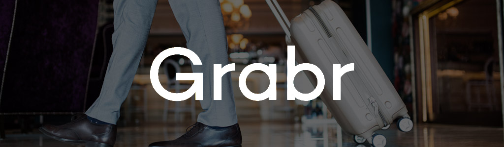 Grabr logo against a darkened background showing someone pulling a wheeled suitcase