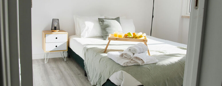 Bedroom with a well-made bed and dining tray in a Vrbo owner's home