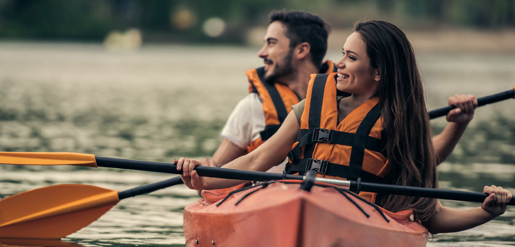 Male and female Airbnb Experience hosts kayaking as part of their side hustle