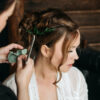 Professional hairstylist arranging an updo for a hair client