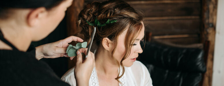Professional hairstylist arranging an updo for a hair client