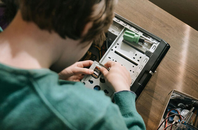 Computer repair business owner repairing computer hardware for a customer